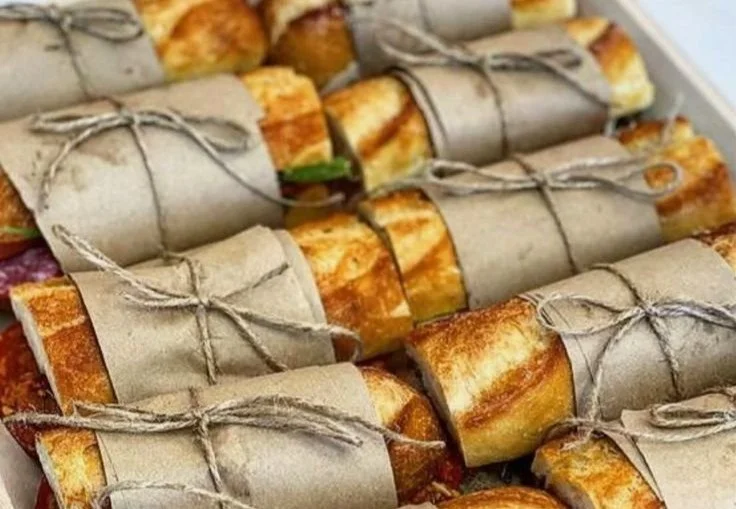 A colorful springtime garden picnic setup with blankets, food, and flowers.