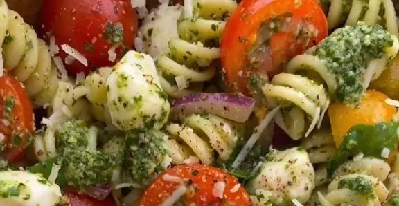 Pesto pasta salad with tomatoes and mozzarella in a bowl